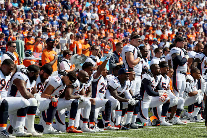 Denver Broncos come together to protest during the national anthem.